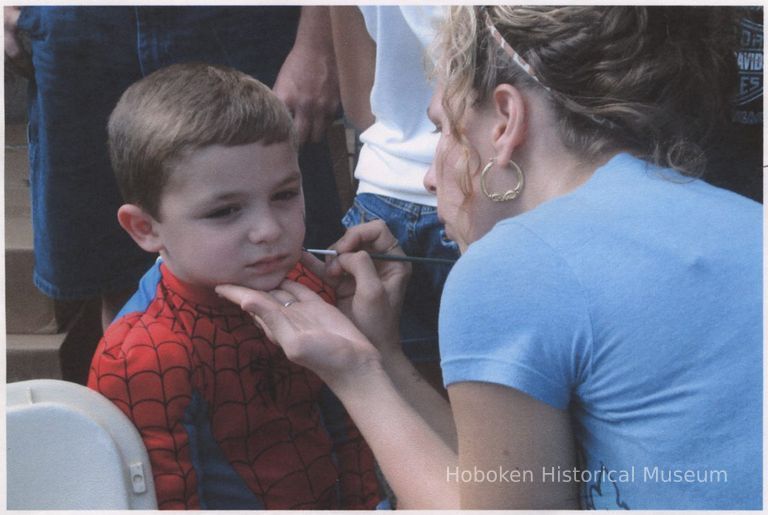 Color photo of a boy getting his face painted by a woman at Biggie's Clam Bar 60th anniversary, Hoboken, Sept. 17, 2006. picture number 1