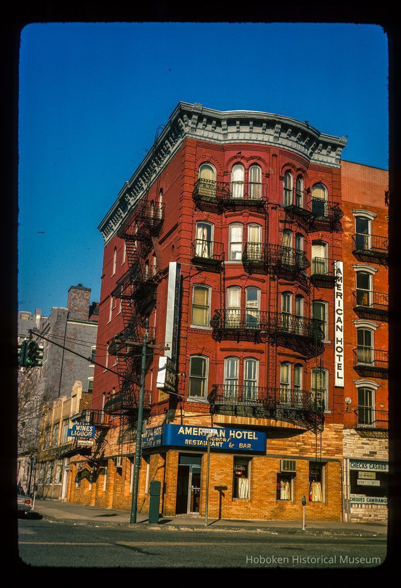 Color slide of eye-level view of front and side façades with fire escape at 76 River on the NW corner of River and Hudson Place occupied by the American Hotel picture number 1