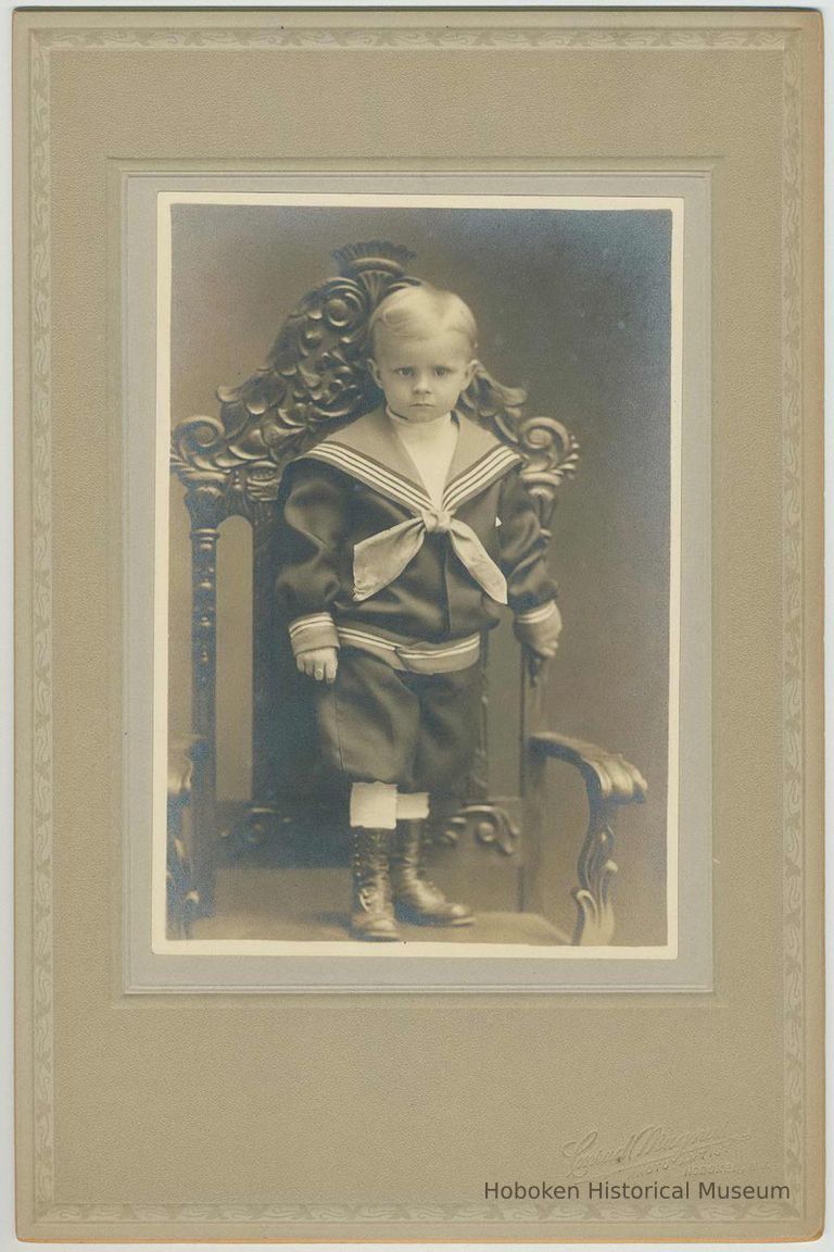 B+W photo of young boy in sailor suit standing on chair, no date (ca. 1900). picture number 1