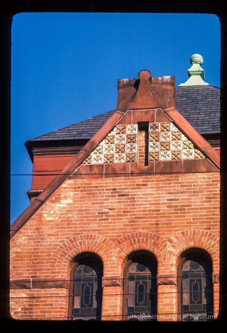 Color slide of detail view of gable brickwork, decorative tile, gauged arches and stained glass windows on the First Baptist Church at 901 Bloomfield on the corner of Bloomfield and 9th picture number 1