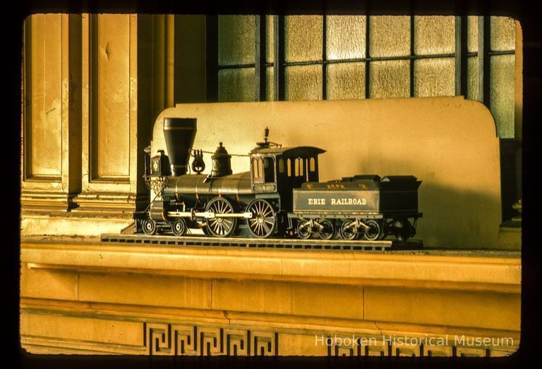 Color slide of interior close-up view of Erie Railroad model train above the north door of the Lackawanna Terminal waiting room picture number 1