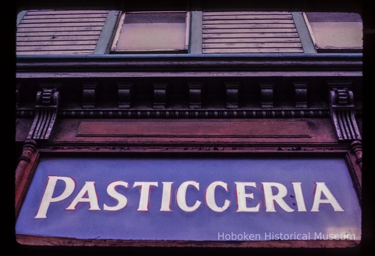 Color slide of close-up view of cornice and storefront signage reading 