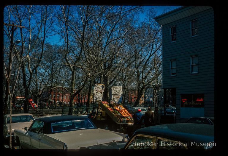 Color slide of eye-level view looking N of produce truck on the SE corner of Park and 4th, the Park Tavern at 343 Park and Church Square Park beyond picture number 1