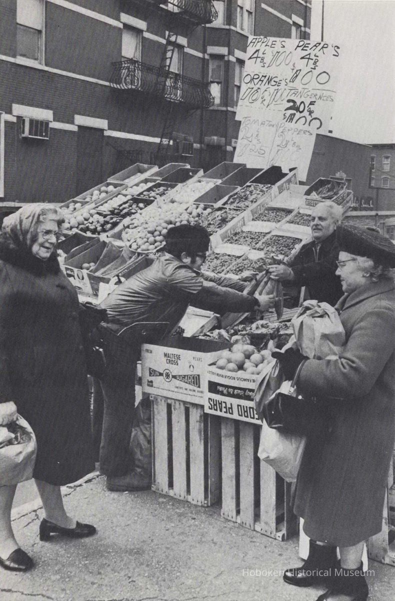 Reference image of printed photo image of a produce truck vendor with customers from pg 34 of archives catalog 2002.026.0002, Hoboken, ca. 1975. picture number 1