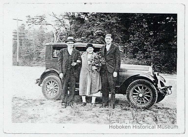 Black-and-white photocopy of photo of August & Gesina Engelbart plus a man standing in front of an automobile, no place, n.d., ca. 1940. picture number 1