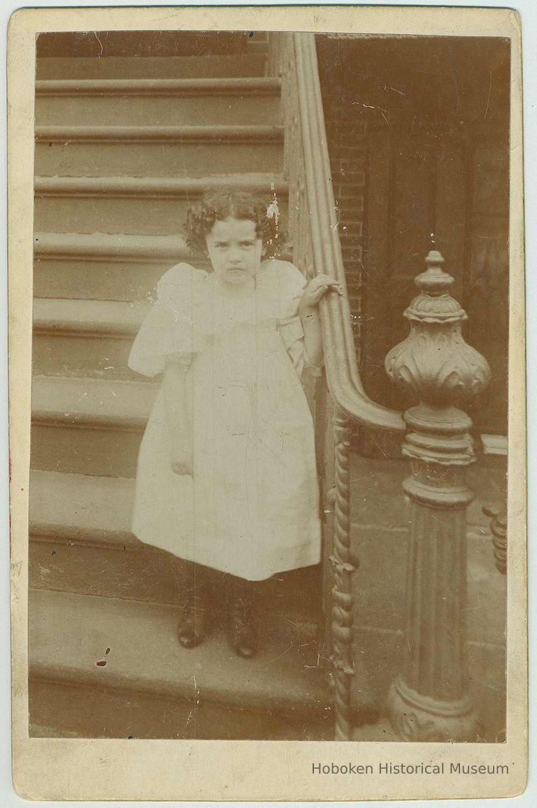 Cabinet photo of unidentified small girl posing at the bottom of front stoop, no place, no date. ca. 1893-95. picture number 1