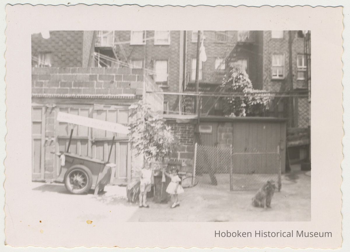 Digital image of b+w photo of Lucille Conti (left) & unknown girl in a backyard near Yum Yum cart at 416 Clinton St., Hoboken, n.d., ca. 1950s. picture number 1