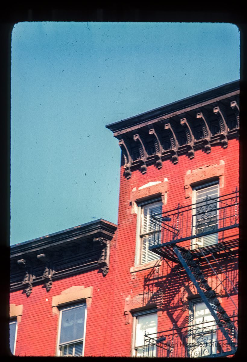 Color slide of detail view of fire escape, cornices, brackets, and window heads on two unidentified buildings picture number 1