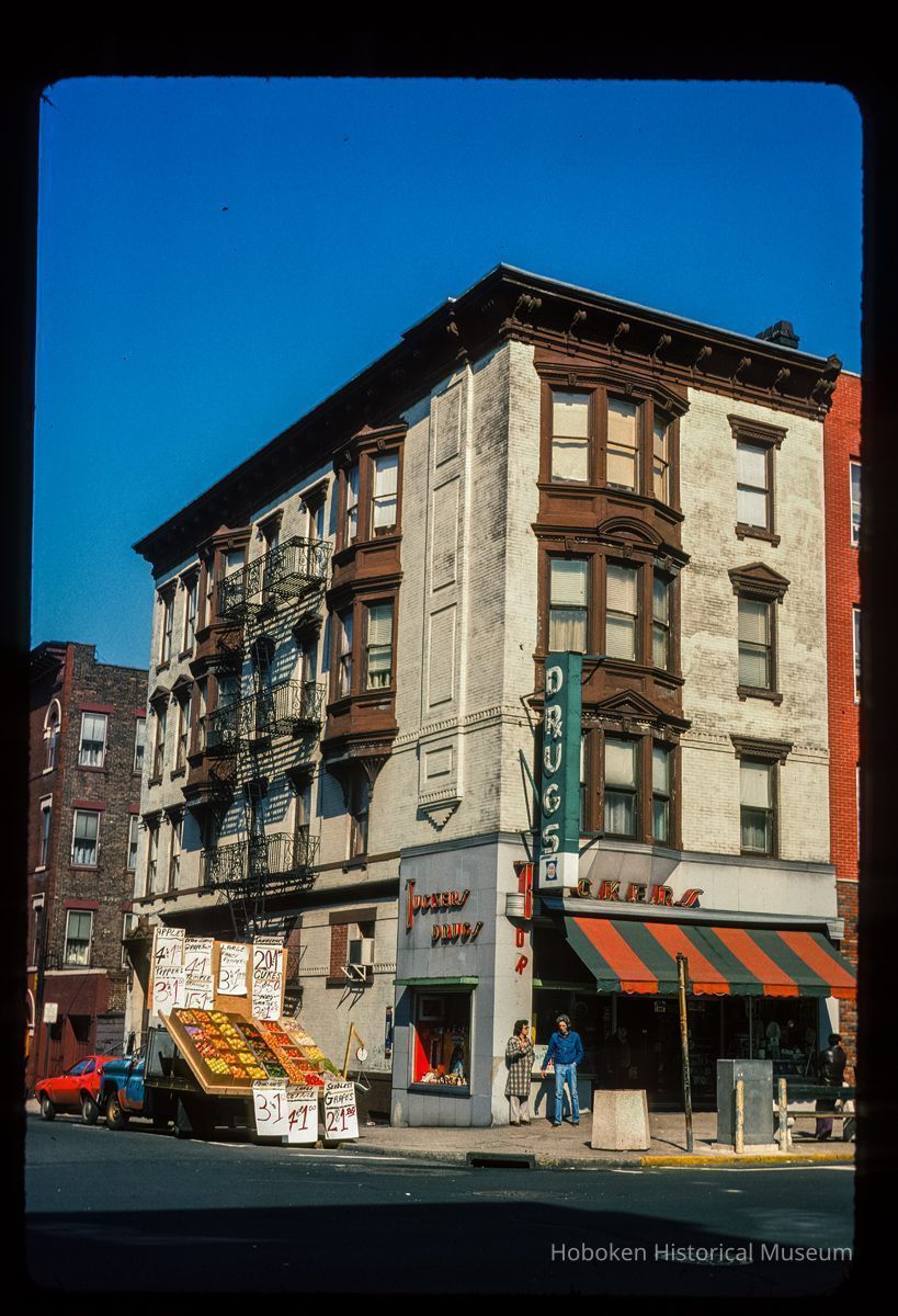 Color slide of eye-level view of 1000 Washington on the NW corner of Washington & 10th occupied by Tucker's Drugs with a produce truck parked on 10th picture number 1
