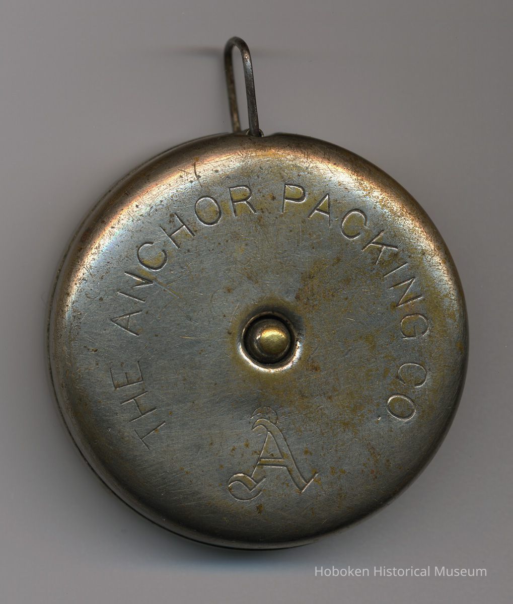 side with custom engraving: Anchor Packing Co.; stop button at center