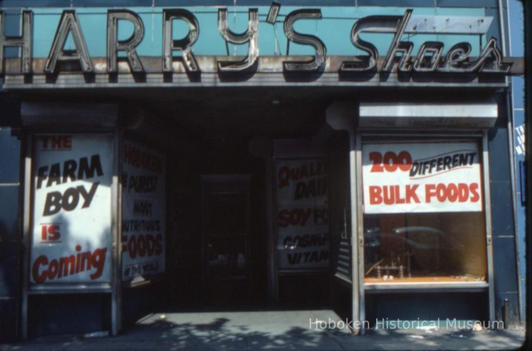 Color slide of the former storefront of Harry's Shoes,128 Washington St.; window sign announcing 