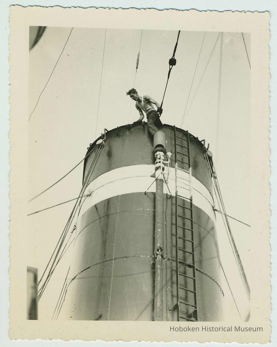 B+W photo of a shipyard worker near the top of a funnel on an unidentified vessel, no date, ca. 1940. picture number 1