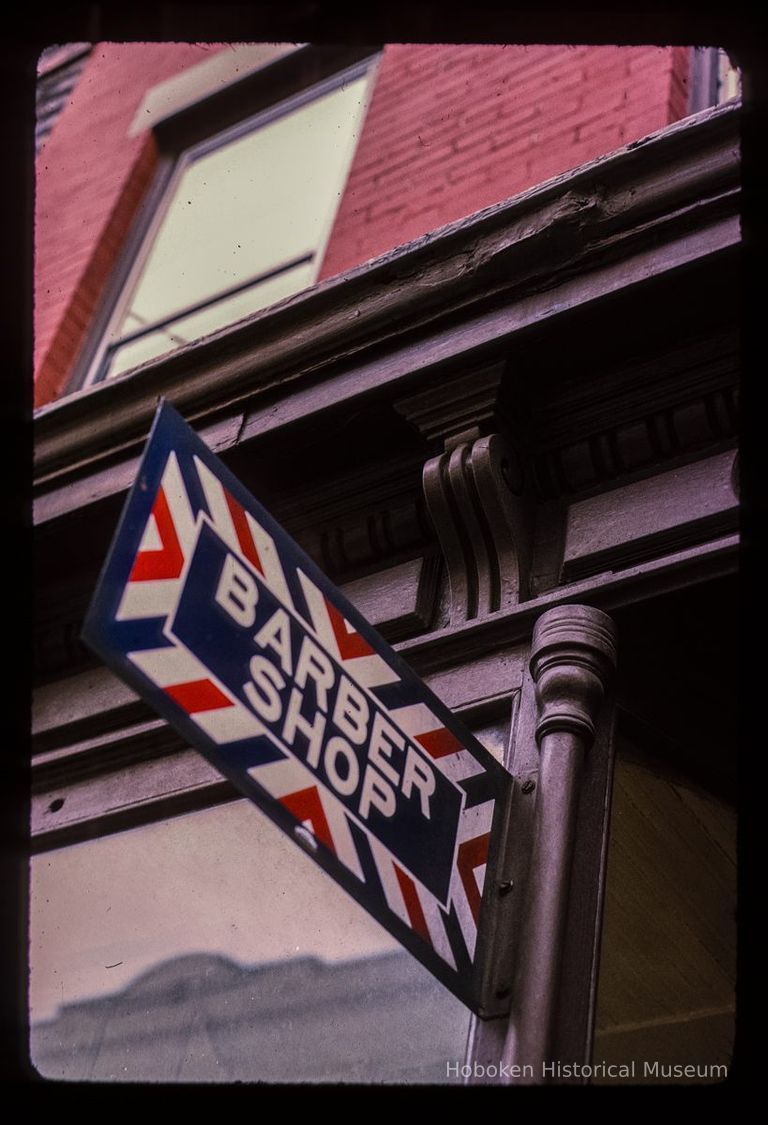 Color slide of close-up view of cornice and storefront signage reading 