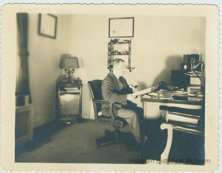 B+W photo of a man in an office, location and date unknown. picture number 1