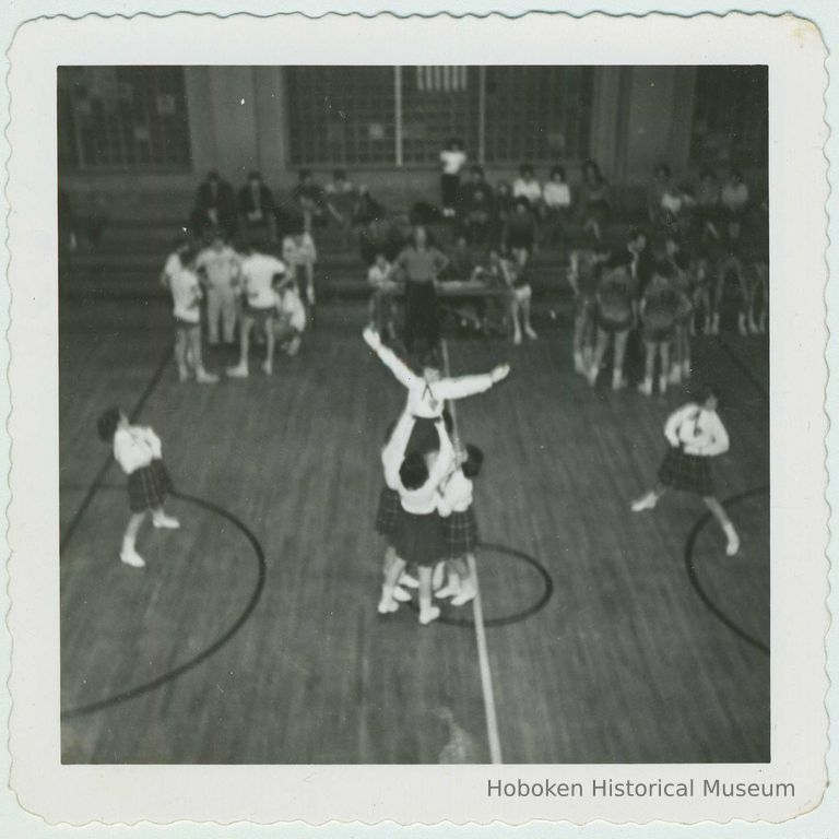 B+W photo of cheerleaders performing a routine in a school gym, Hoboken, no date, ca. 1955. picture number 1