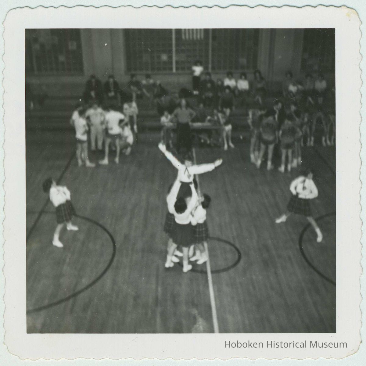 B+W photo of cheerleaders performing a routine in a school gym, Hoboken, no date, ca. 1955. picture number 1