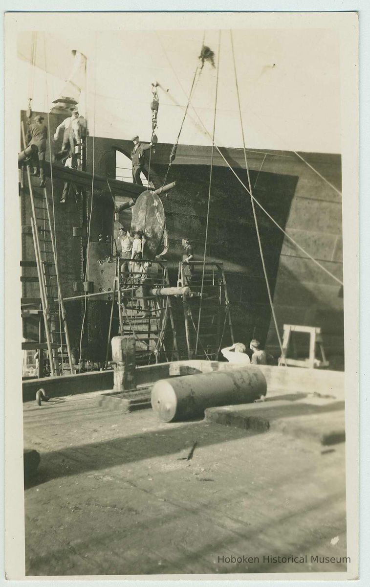 B+W photo print as postcard view of shipyard riggers with propeller of an unidentified vessel in drydock, no date, ca. 1940. picture number 1