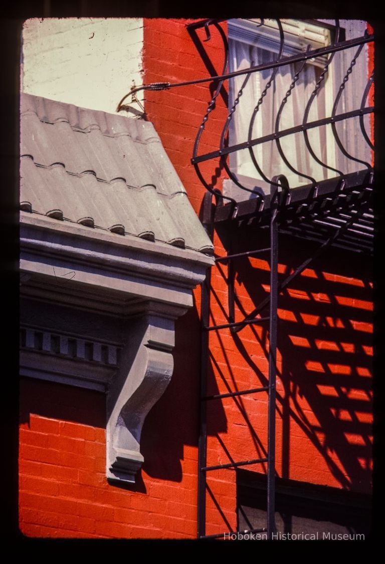 Color slide of detail view of cornice, dentils, bracket and fire escape on the 8th Street side of 800 Bloomfield on the NW corner of Bloomfield and 8th picture number 1