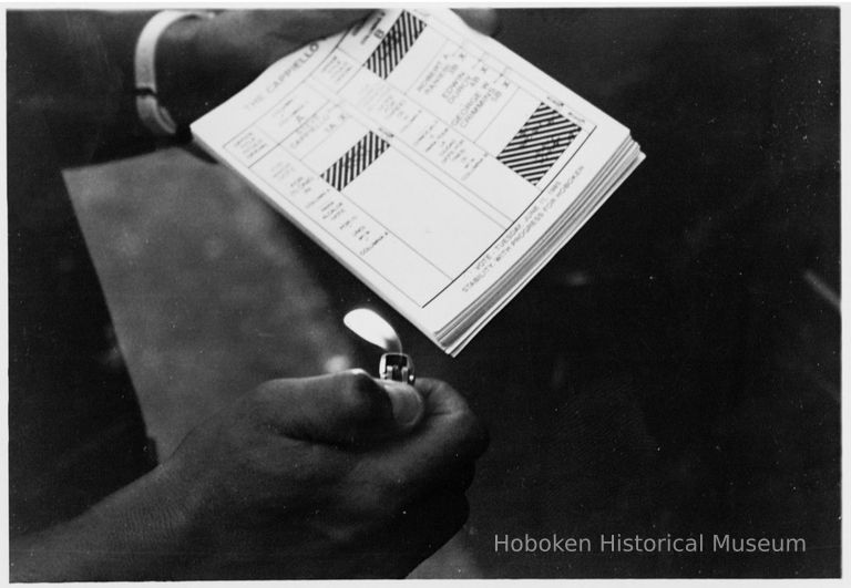 B+W photo of a person about to light a stack of Cappiello ticket handbills on election day, Hoboken, [June 11, 1985]. picture number 1