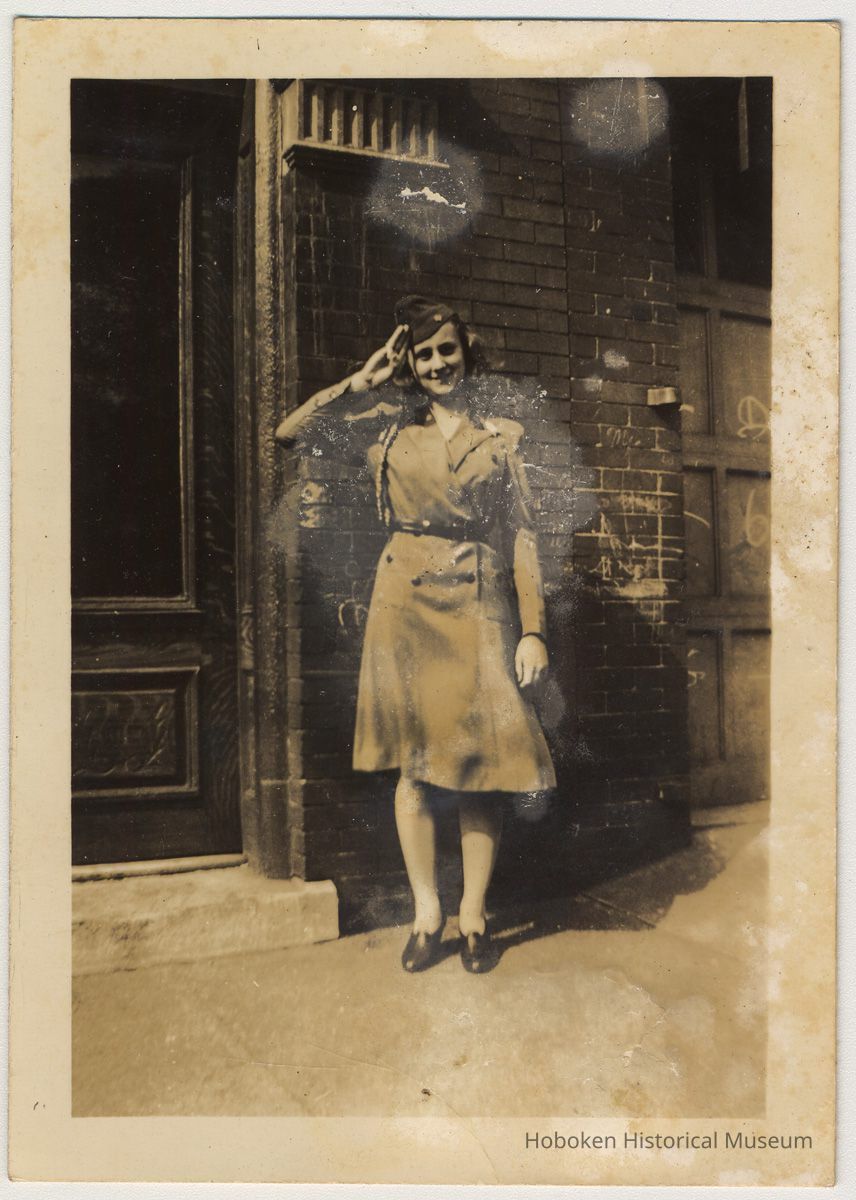 Sepia-toned photo of a woman in military uniform outside 108 Tenth St., Hoboken, no date, probably 1941-1945. picture number 1