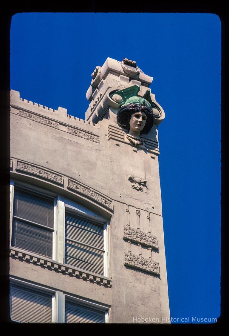 Color slide of detail view of roofline figurine and decorative tiles of the Terminal Building at 70 Hudson Street on the NW corner of Hudson Place picture number 1