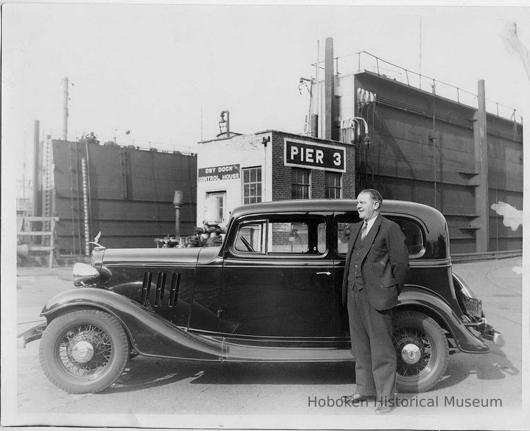 B+W photo of man in suit next to a black automobile, Pier 3, Beth Steel, Hoboken, no date, ca. 1940 picture number 1