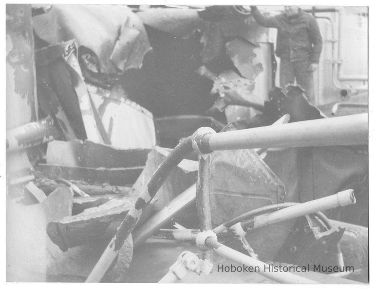 B+W photo of a worker surveying damage to unknown ship, Hoboken, no date, ca. 1940. picture number 1