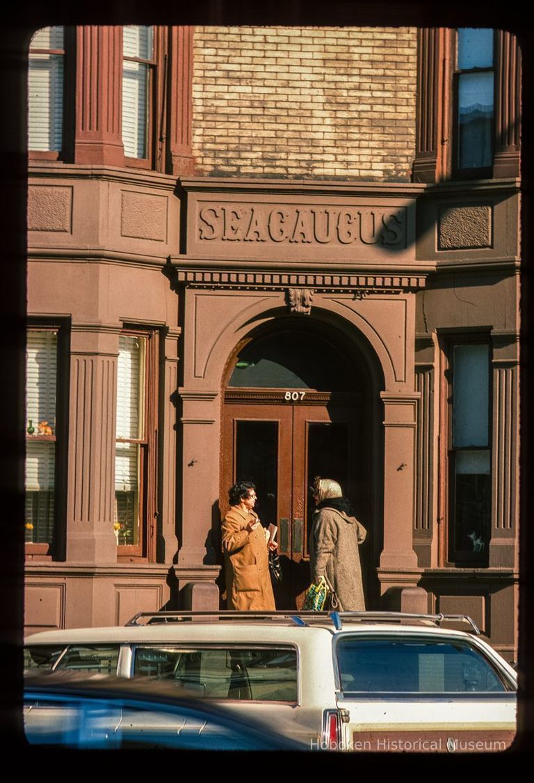 Color slide of close-up view of portico, bracket, dentils, bay windows and frieze reading 