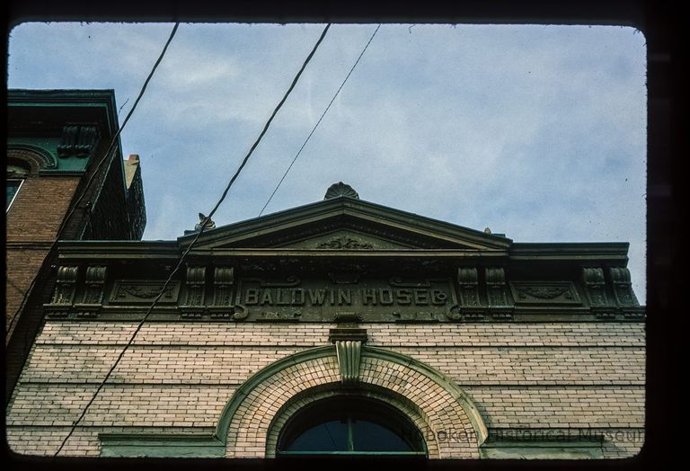 Color slide of detail view of pediment, cornice, brackets, frieze reading 