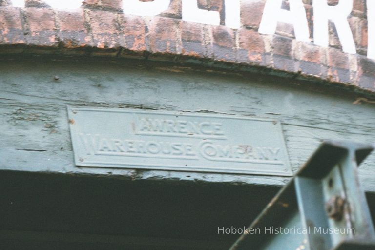 Color photo of the metal sign, Lawrence Warehouse Company, under the Receiving Entrance sign at 722 Grand St., Hoboken, Jan. 3 & 4, 2002. picture number 1