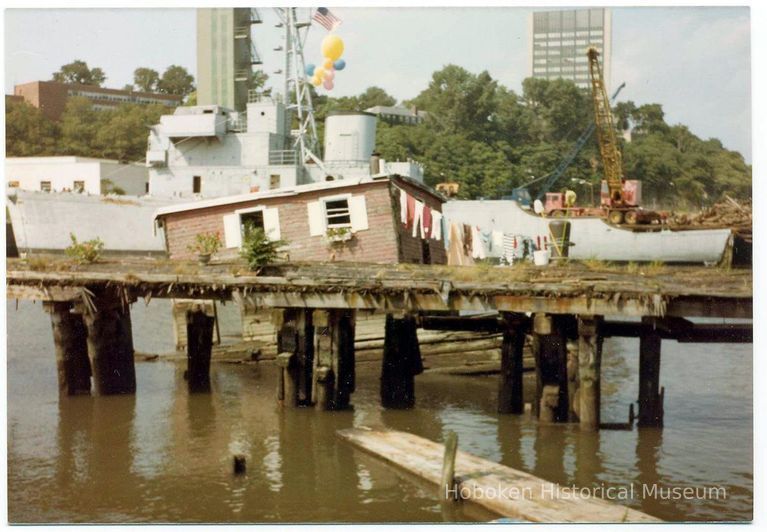 Color photo of houseboat berthed at Hudson River pier, Hoboken, N.J., 1981. picture number 1