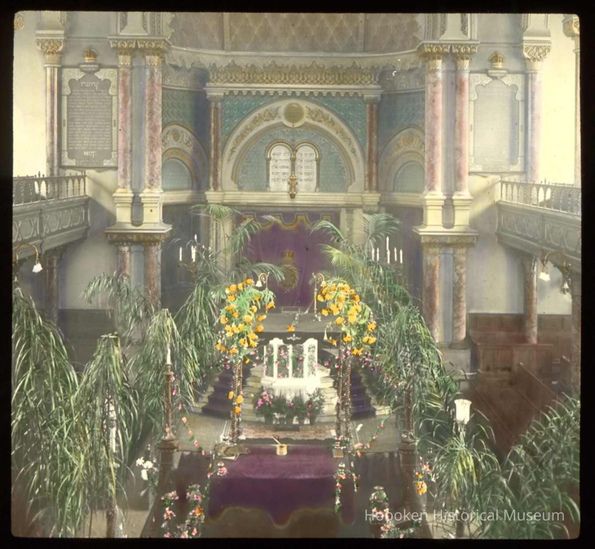 Lantern slide, color, of a synagogue interior with floral decorations, used for promotional display in Hoboken, no date, ca. 1920. picture number 1