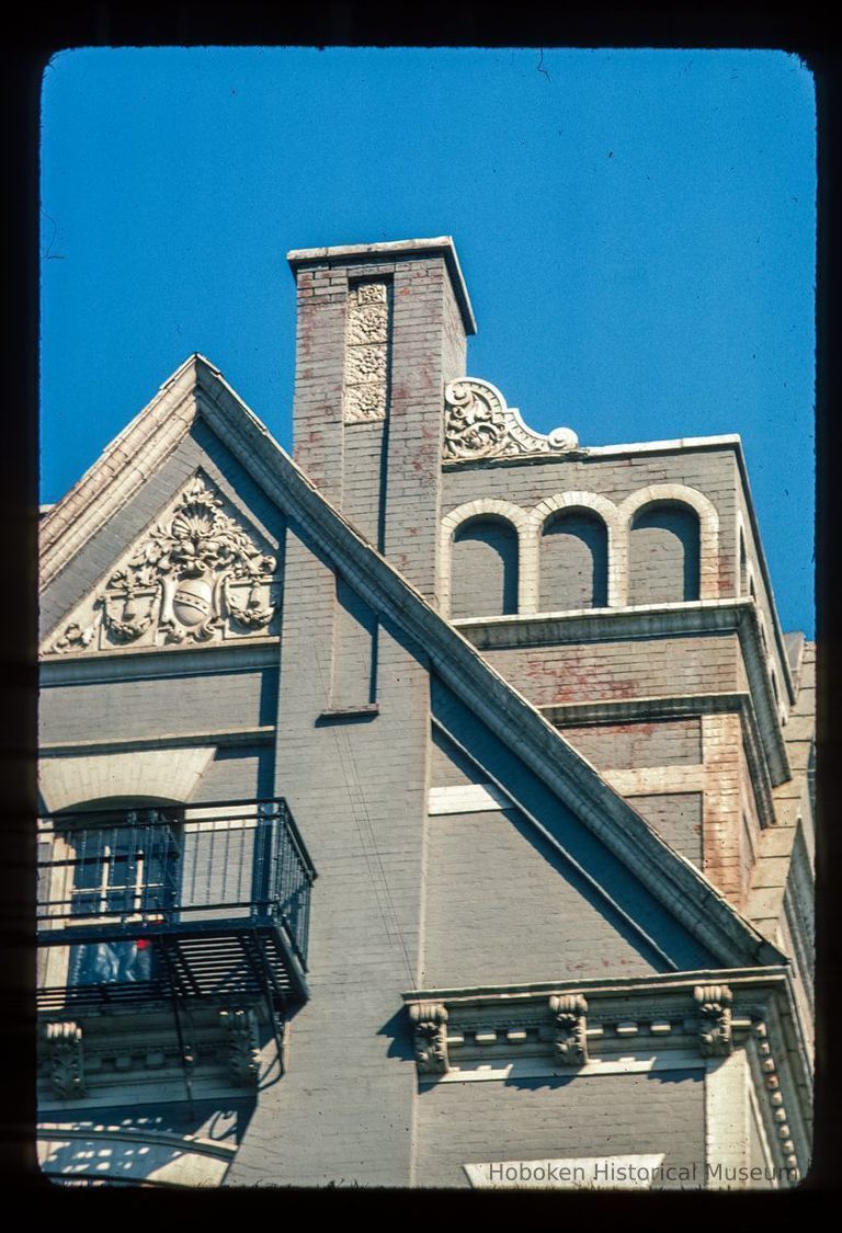 Color slide of detail view of cornice, pediment, chimney, brackets, dentils and fire escape at 77 Hudson Street on the NE corner of Hudson Place picture number 1