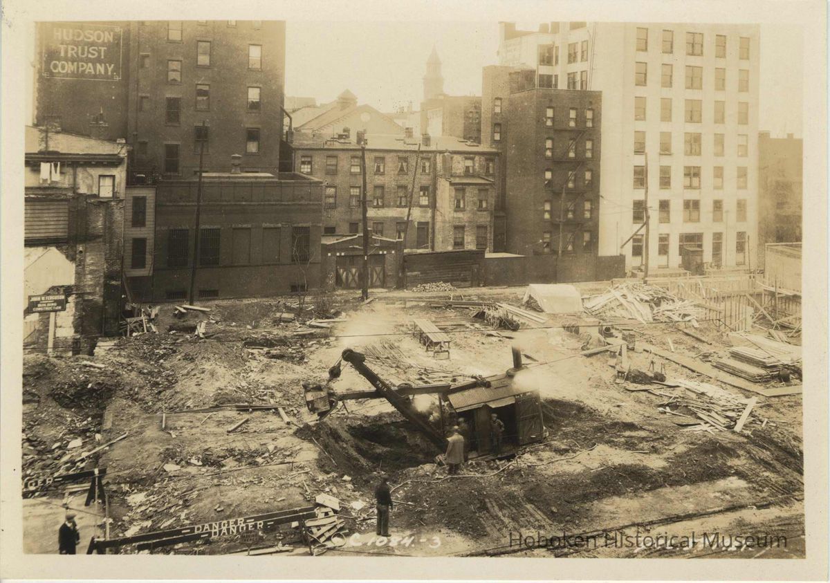 Sepia-tone photo of foundation preparation on the site for the Fabian Theatre, southeast corner of Newark & Washington Sts., Hoboken, Dec. 3, 1927. picture number 1