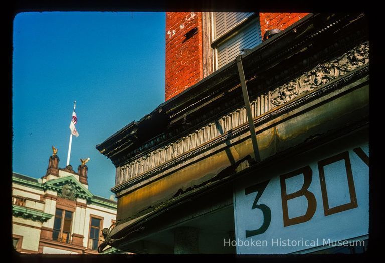 Color slide of detail view of cornice on the NE corner of Newark & Washington with Hoboken City Hall pediment and flagpole in the background picture number 1