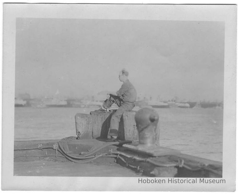 B+W photo of photographer & shipyard employee William Craig sitting at the end of a pier, Hoboken, no date, ca 1940. picture number 1