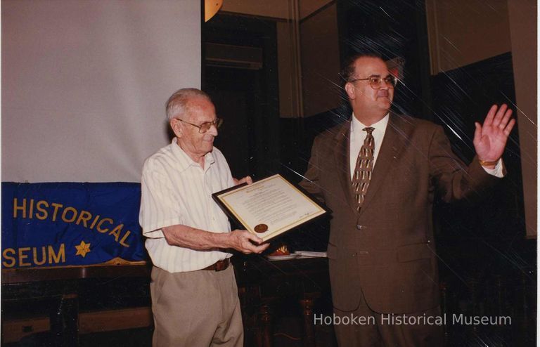 Color photo of Hudson County Freeholder Maurice Fitzgibbons handing a Proclamation to George Kirchgessner, Hoboken City Hall, June 27, 1997. picture number 1