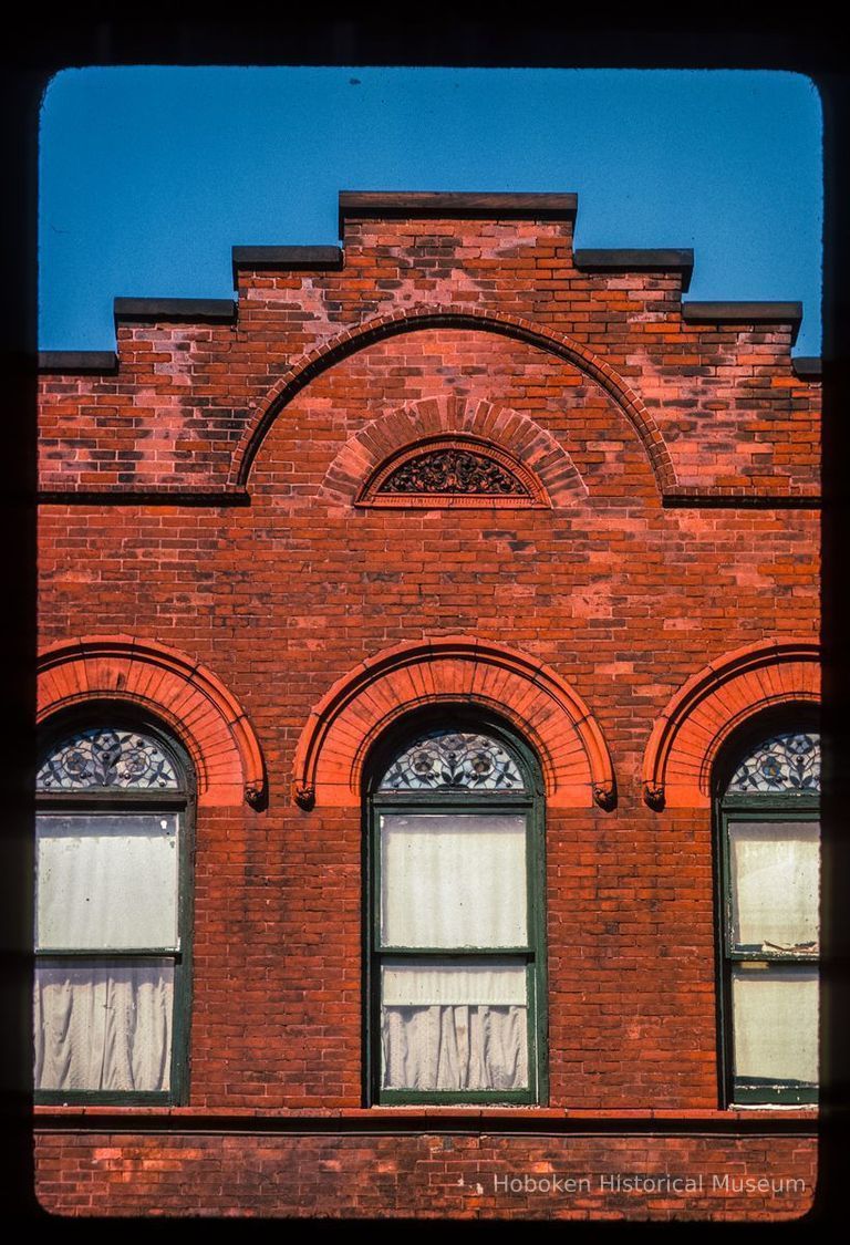 Color slide of close-up view of brick pediment, semicircular arches and stained glass window heads at 814 Hudson between 8th and 9th picture number 1