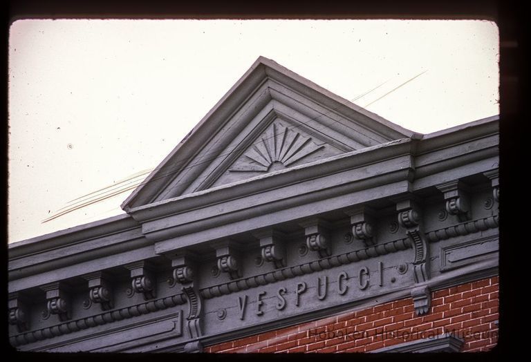 Color slide of close-up view of pediment, cornice, brackets and frieze reading 