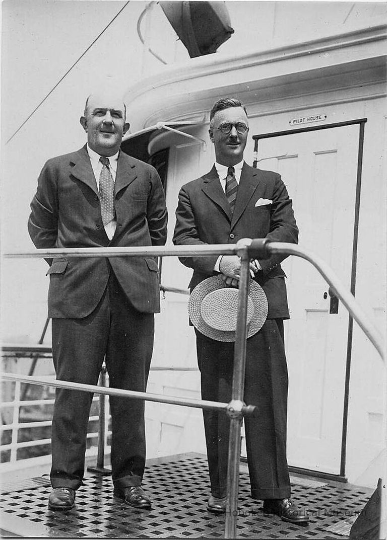 B+W photo of 2 businessmen in suits standing in front of door to pilot house on unidentified vessel, Hoboken, no date, ca. 1940. picture number 1