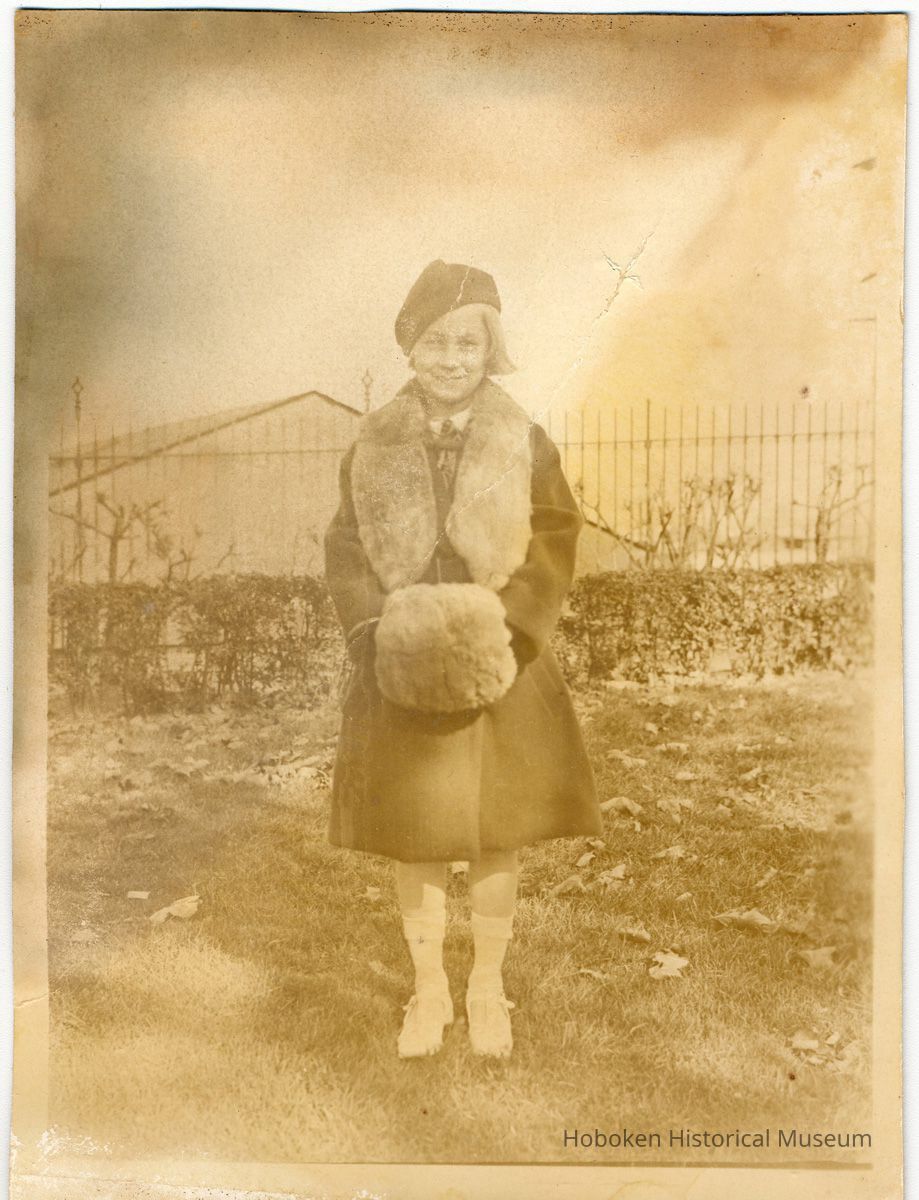 Sepia-toned photo of a young girl in winter coat taken in Elysian Park, Hoboken, no date, ca. 1924-1926. picture number 1