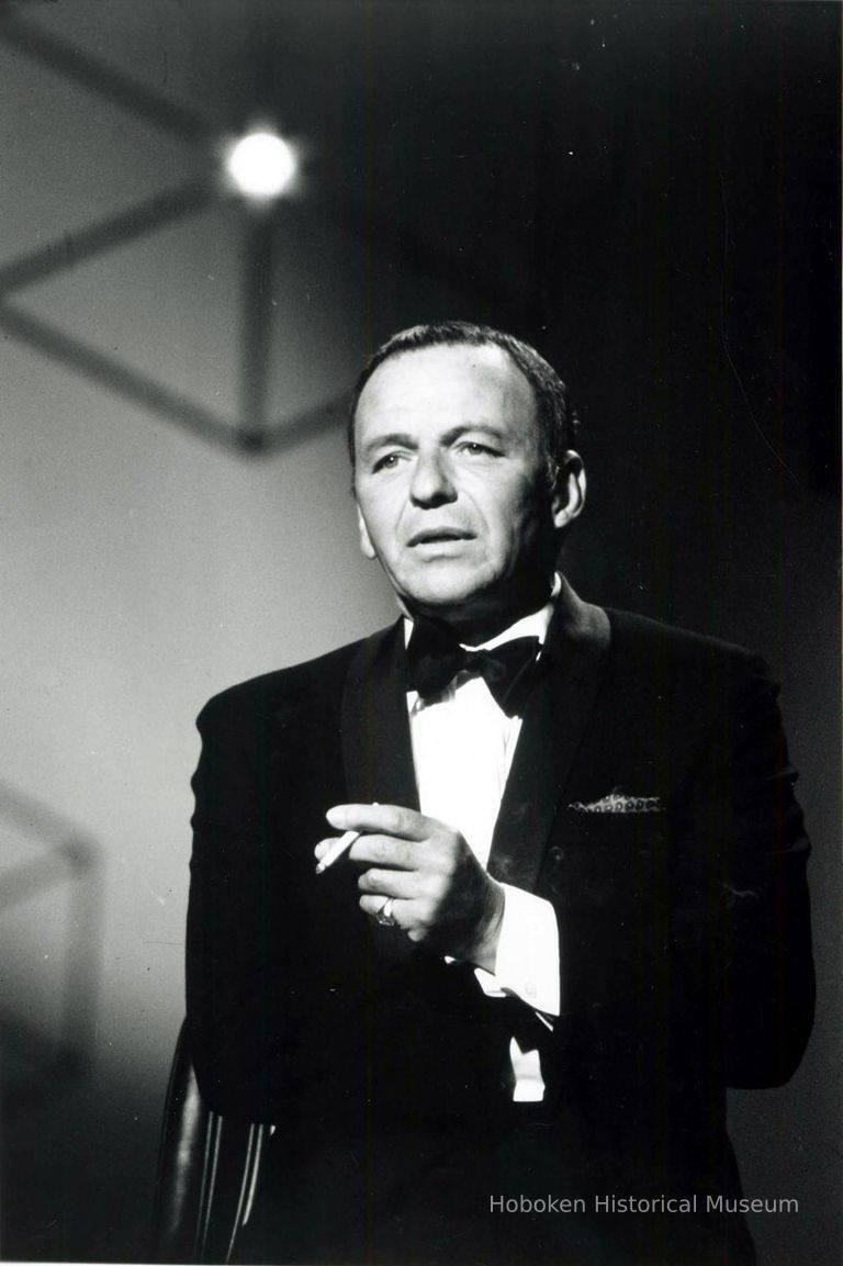 Black-and-white photo of Frank Sinatra in tuxedo on stage with cigarette, no place, no date, ca. 1965. picture number 1