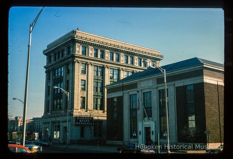 Color slide of eye-level view of the façades of the U.S. Post Office building on the right at 89 River and the Steneck Building/Seaboard Building on the left at 95 River occupied by the Garden State National Bank between Newark and 1st picture number 1