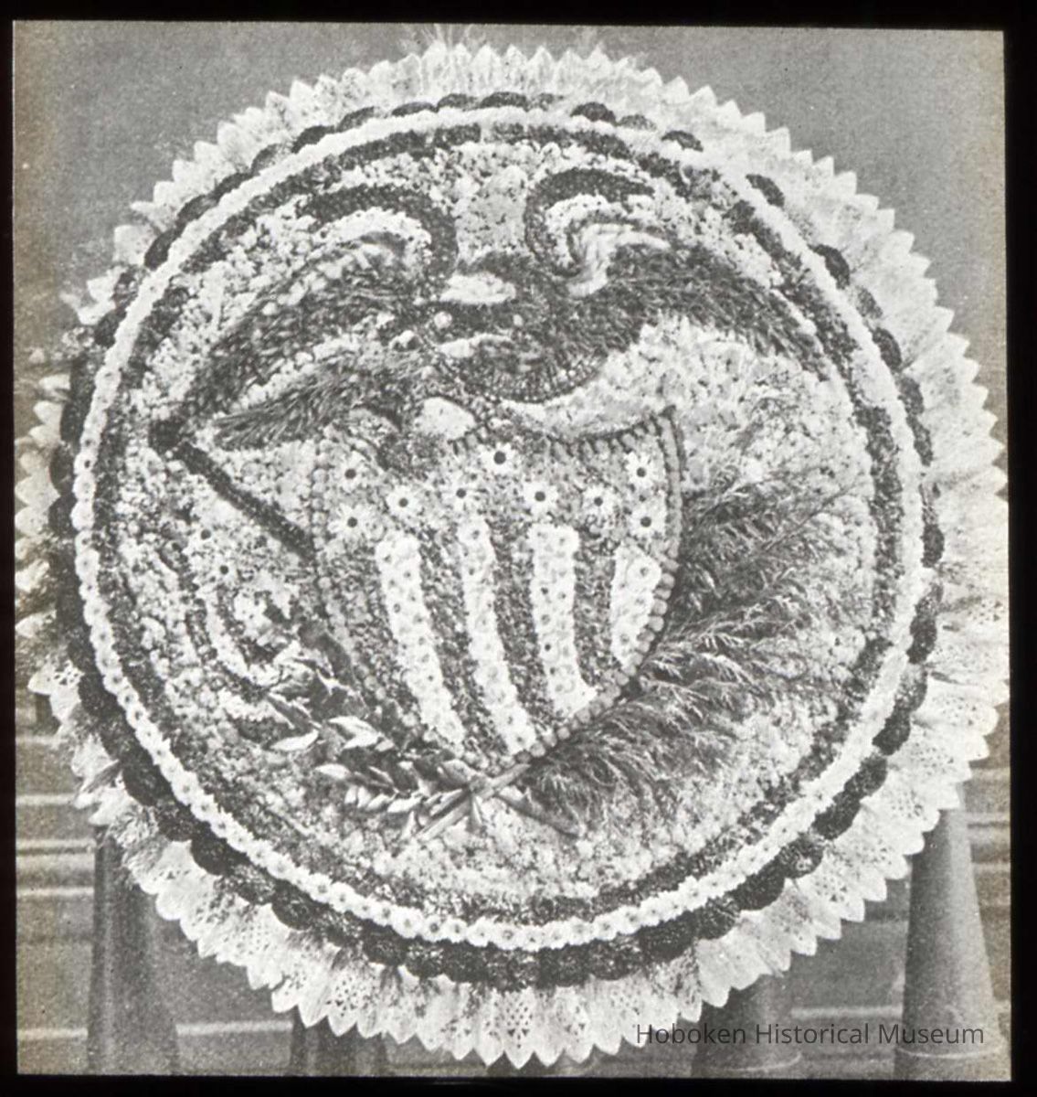 Lantern slide, b+w, of floral decoration with eagle and patriotic shield motif, used for promotional display in Hoboken, no date, ca. 1920. picture number 1