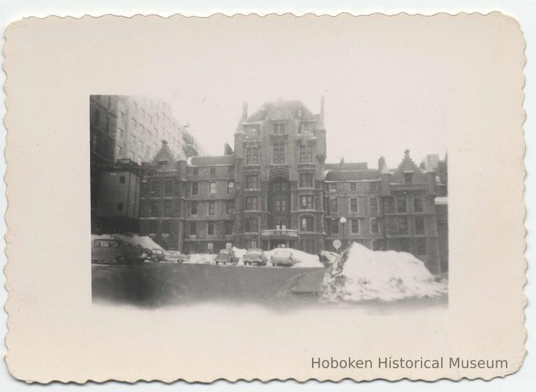 B+W photo of a winter-time view of building (school?) exterior with parking lot and automobiles, Hoboken?, no date, ca. mid-1950's. picture number 1