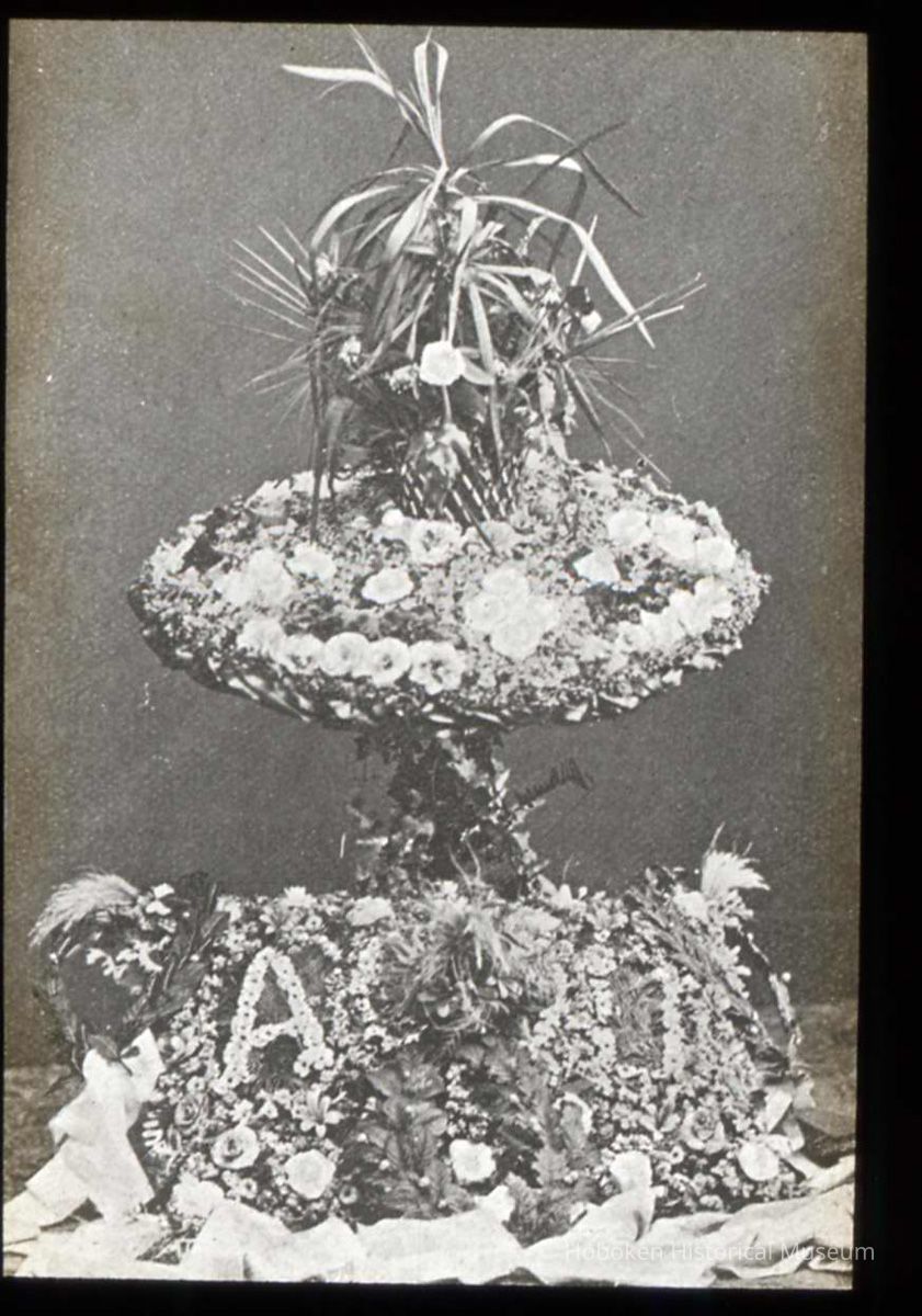 Lantern slide, b+w, of a table floral decoration with lettering, used for promotional display in Hoboken, no date, ca. 1920. picture number 1