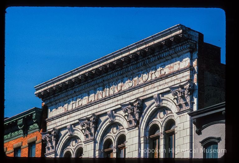 Color slide of close-up view of cornices, dentils, pilasters, arched windows and frieze reading 