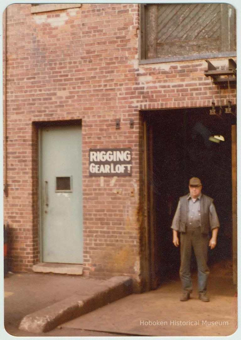 Color photo of Charlie Kosbab standing in the doorway of the Rigging Gear Loft at the Bethlehem Steel Shipyard, Hoboken Division, ca. 1980. picture number 1