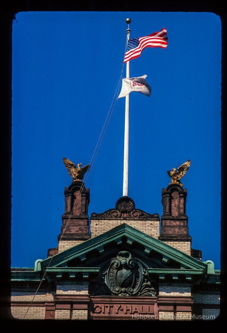 Color slide of detail view of flagpole, eagle ornaments, cornice, pediment, and frieze on Hoboken City Hall, 94 Washington between Newark & 1st picture number 1