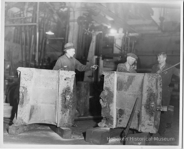 B+W photo of propeller hub halves showing interior with 2 workers and a supervisor picture number 1